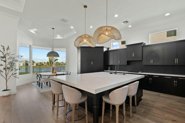 kitchen with pendant lighting, backsplash, a spacious island, and a breakfast bar area