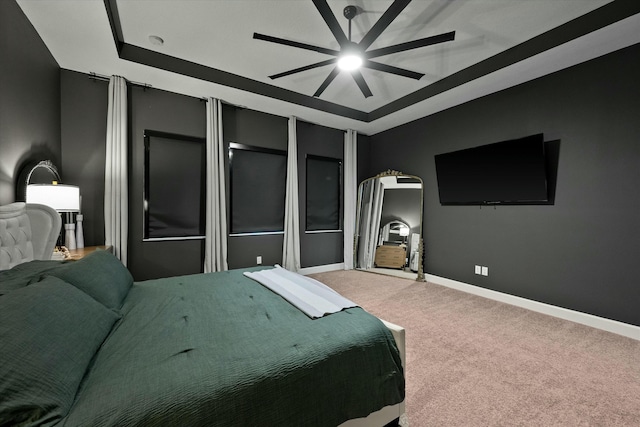 bedroom with carpet, a tray ceiling, and ceiling fan