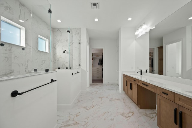 bathroom featuring a tile shower and vanity