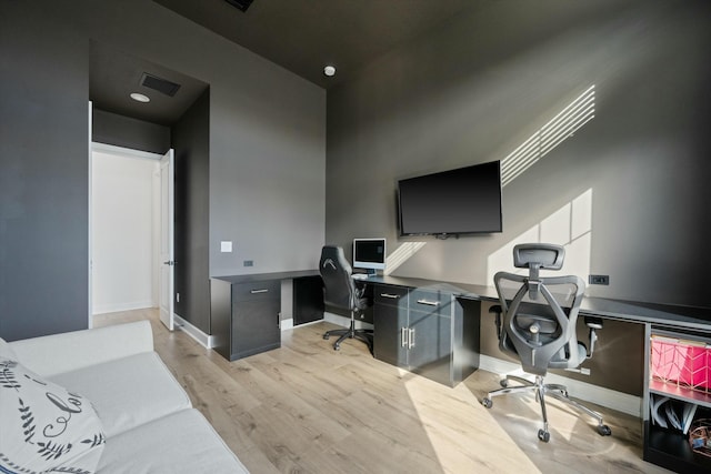 home office featuring built in desk and light wood-type flooring