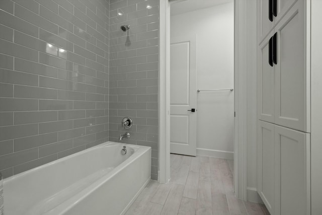 bathroom featuring hardwood / wood-style floors and tiled shower / bath combo