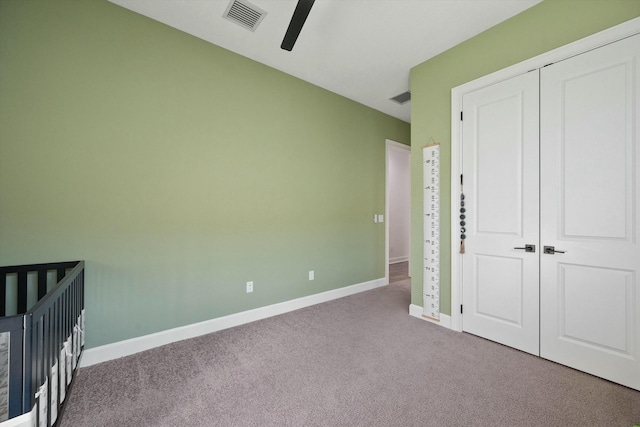 unfurnished bedroom featuring a closet, ceiling fan, and light colored carpet