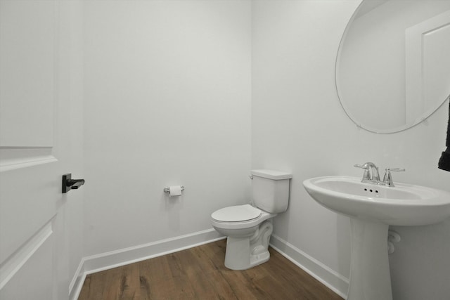 bathroom featuring sink, wood-type flooring, and toilet