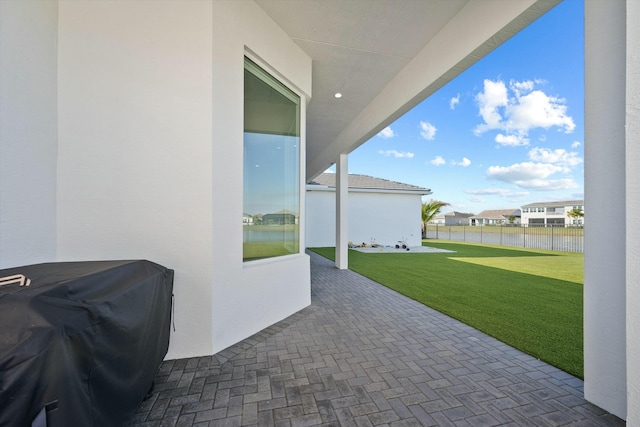 view of patio with a grill and a water view