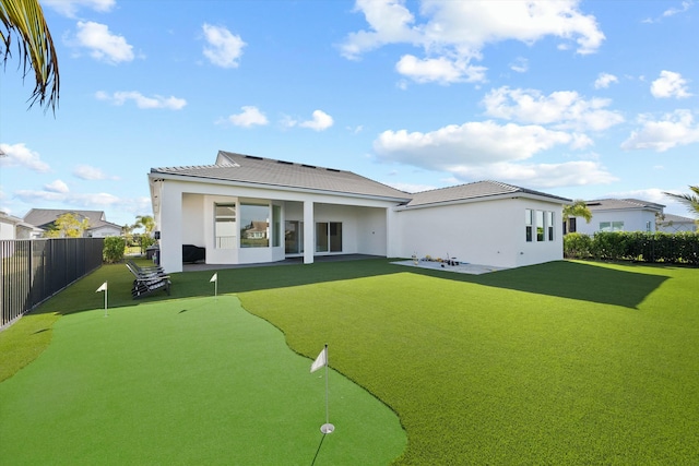 rear view of house featuring a lawn