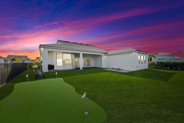 back house at dusk with a yard