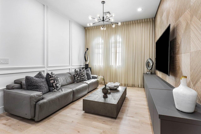 living room with a notable chandelier and light hardwood / wood-style flooring