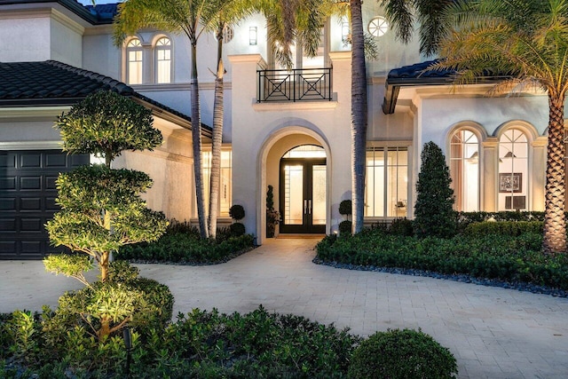 view of exterior entry with french doors and a balcony