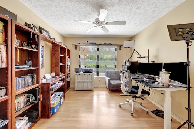 office space featuring ceiling fan, light hardwood / wood-style flooring, and a textured ceiling