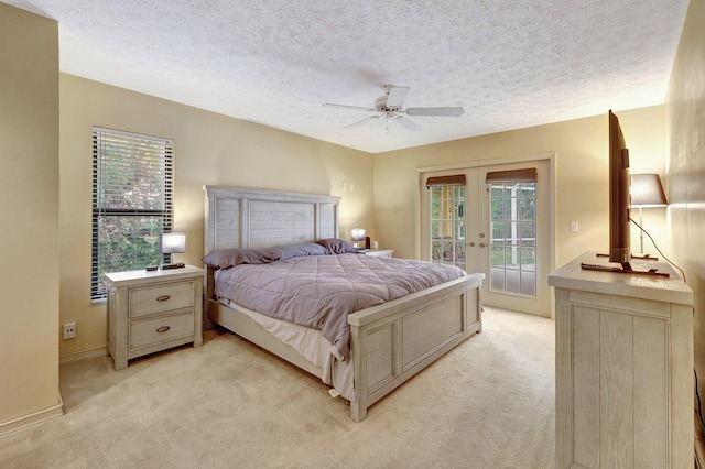 bedroom featuring a textured ceiling, access to outside, french doors, light carpet, and ceiling fan