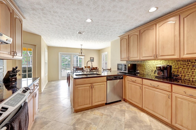 kitchen with kitchen peninsula, stainless steel appliances, decorative light fixtures, and sink