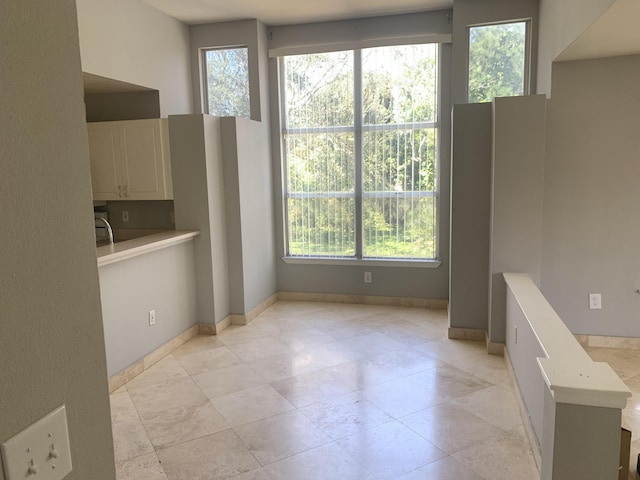 unfurnished dining area featuring light tile patterned flooring