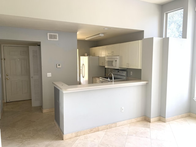 kitchen featuring kitchen peninsula, light tile patterned floors, white appliances, and white cabinetry