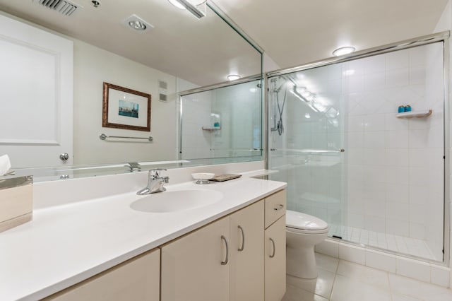 bathroom with tile patterned flooring, vanity, an enclosed shower, and toilet