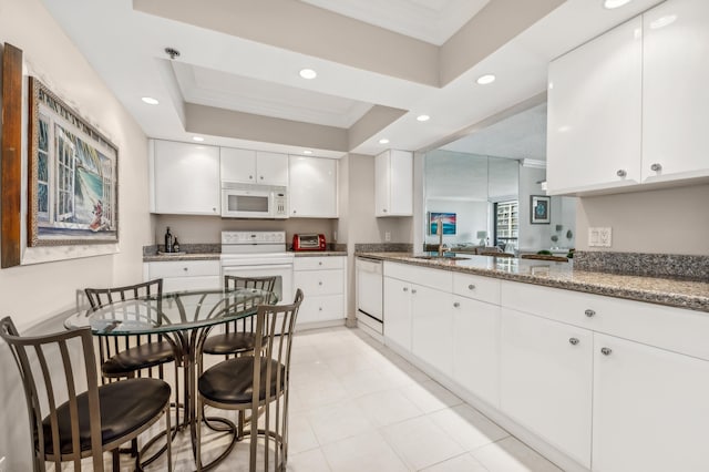 kitchen with white cabinets, stone countertops, white appliances, and ornamental molding