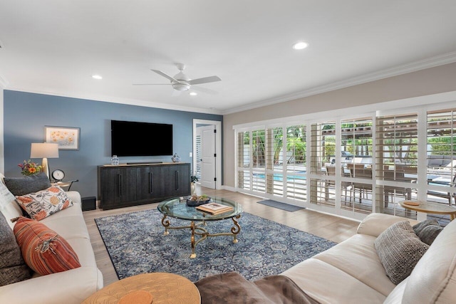 living room with ceiling fan, light wood-type flooring, and ornamental molding