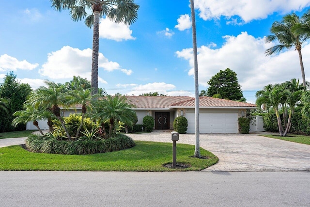 view of front of property featuring a front lawn and a garage