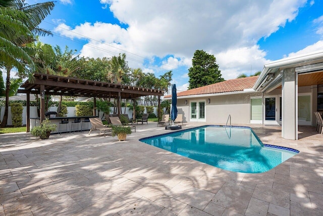 view of pool with an outdoor bar, a patio area, and a pergola