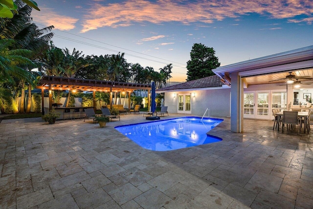 pool at dusk featuring ceiling fan, a pergola, a bar, and a patio