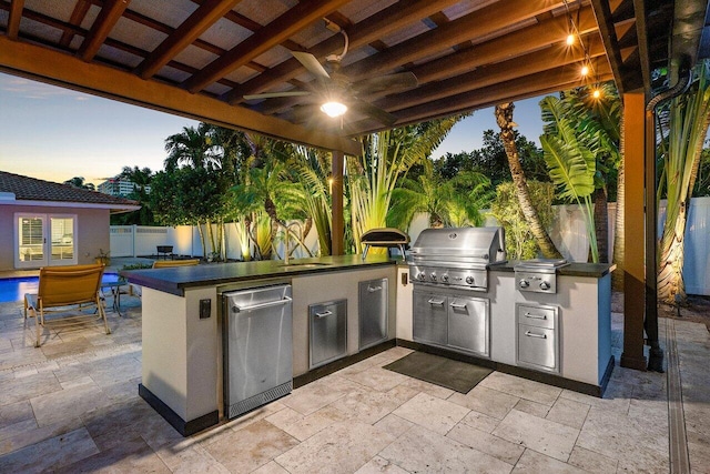 patio terrace at dusk featuring area for grilling