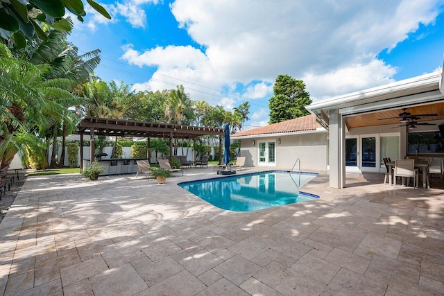 view of swimming pool with a bar, a patio, ceiling fan, and a pergola