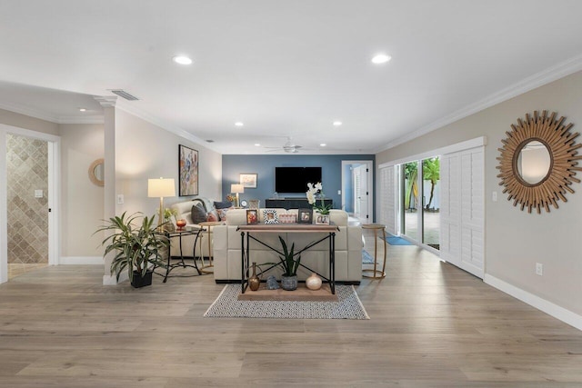 living room with ceiling fan, ornamental molding, and light hardwood / wood-style flooring