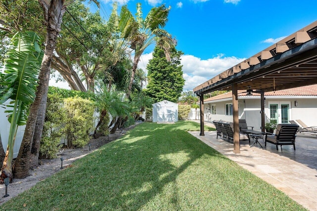 view of yard featuring a patio area, ceiling fan, and a storage unit