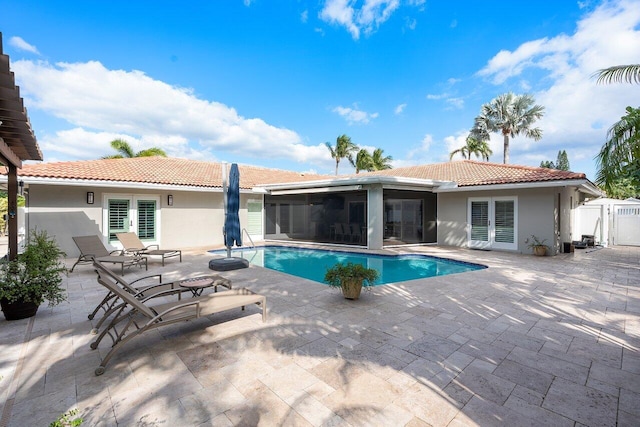 view of swimming pool with a patio area and a sunroom