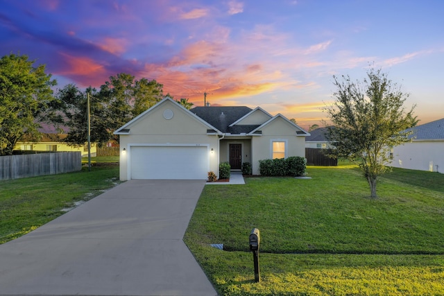 ranch-style house featuring a yard and a garage