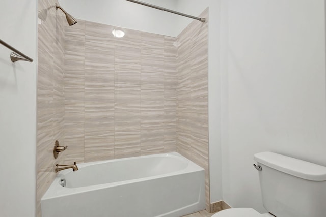 bathroom featuring toilet and tiled shower / bath