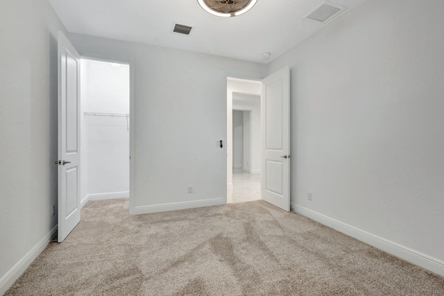 unfurnished bedroom featuring light carpet and a closet