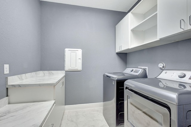 washroom with cabinets and washer and clothes dryer