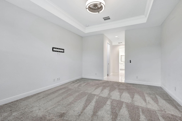 unfurnished room with light carpet, a raised ceiling, and crown molding