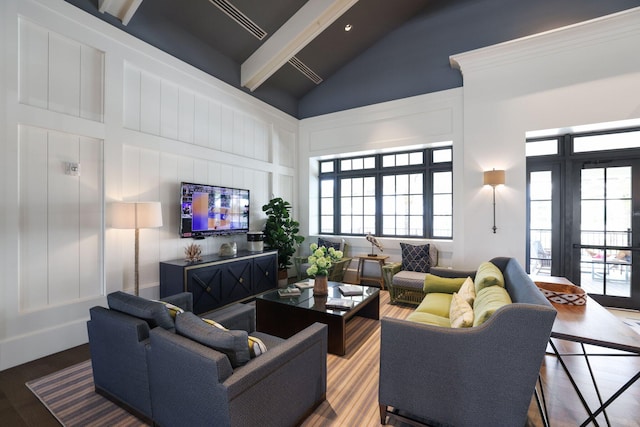 living room featuring hardwood / wood-style flooring, beam ceiling, and high vaulted ceiling