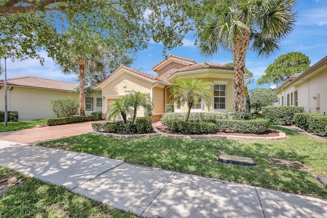 mediterranean / spanish house featuring a front yard