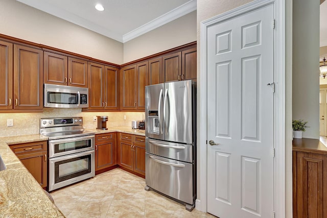 kitchen featuring tasteful backsplash, light stone countertops, stainless steel appliances, and ornamental molding