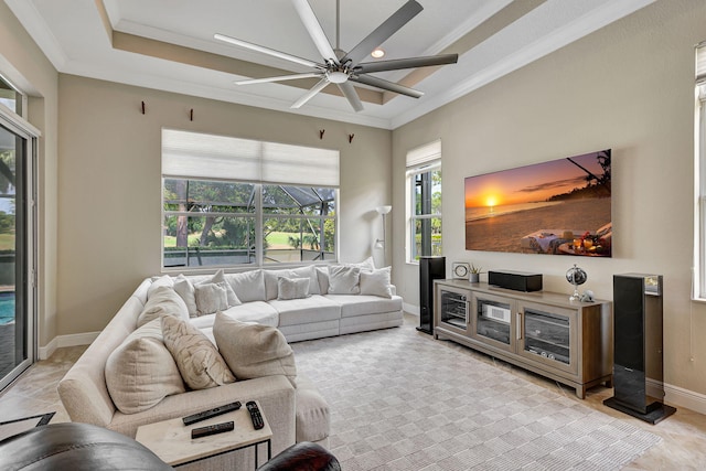 living room featuring ceiling fan, crown molding, and a tray ceiling