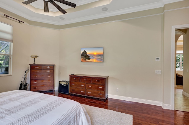 bedroom with multiple windows, ceiling fan, dark hardwood / wood-style floors, and ornamental molding