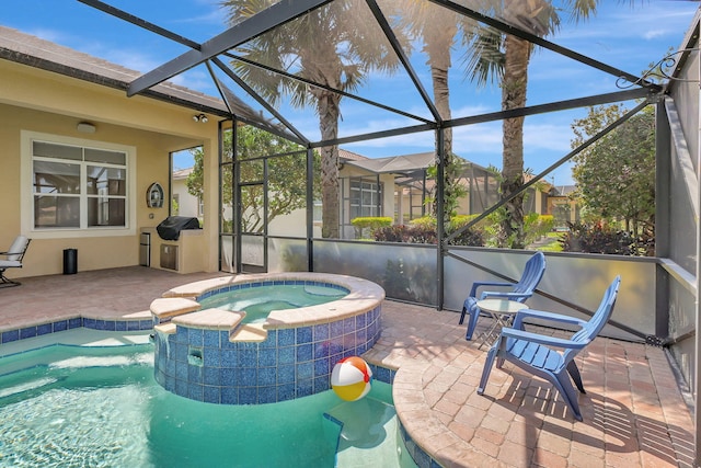 view of pool featuring glass enclosure, a patio area, an in ground hot tub, and grilling area