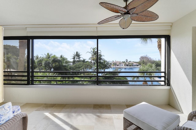 sunroom / solarium with ceiling fan, a water view, and a healthy amount of sunlight