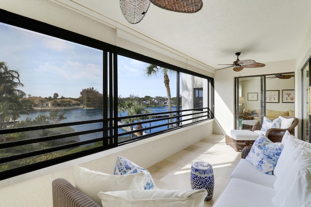 sunroom with a water view and ceiling fan