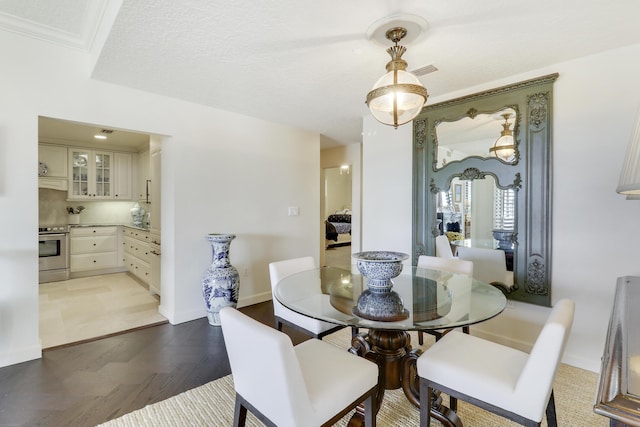 dining room with wood-type flooring and ornamental molding