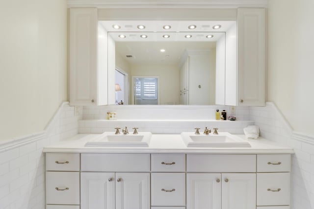 bathroom with vanity and tile walls