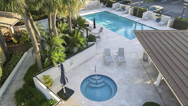 view of swimming pool featuring a patio area and a hot tub