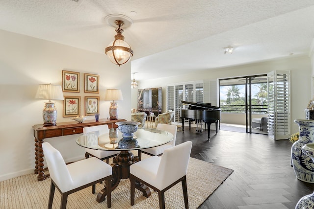 dining space featuring dark parquet flooring and a textured ceiling