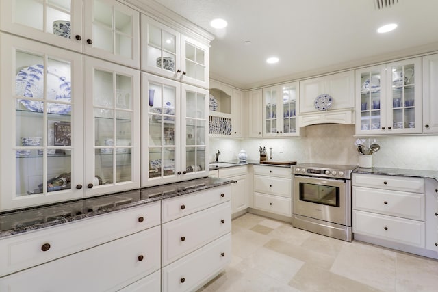 kitchen with white cabinets, backsplash, electric stove, and sink