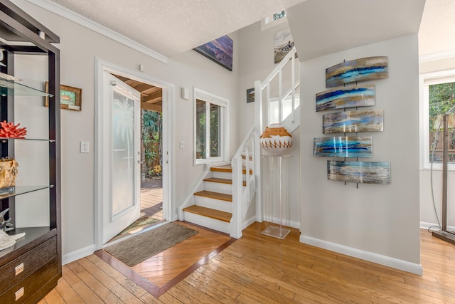 entryway with plenty of natural light, a textured ceiling, and light hardwood / wood-style flooring