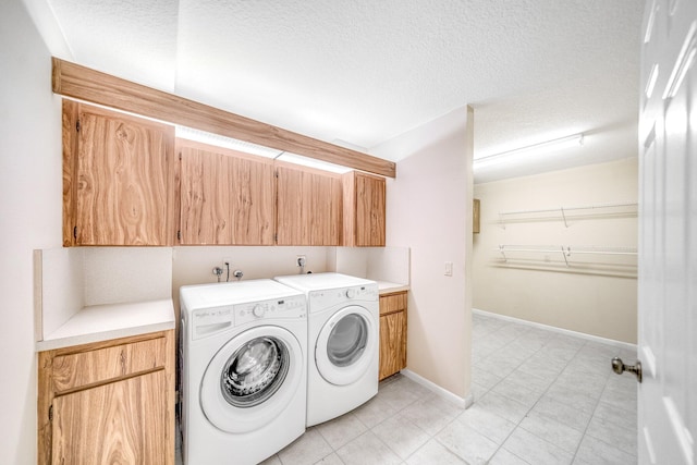 laundry area with cabinets, independent washer and dryer, and a textured ceiling