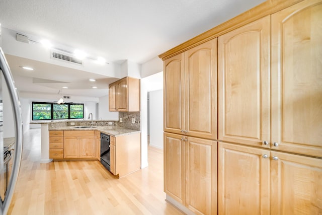 kitchen with sink, light hardwood / wood-style flooring, decorative backsplash, black dishwasher, and kitchen peninsula