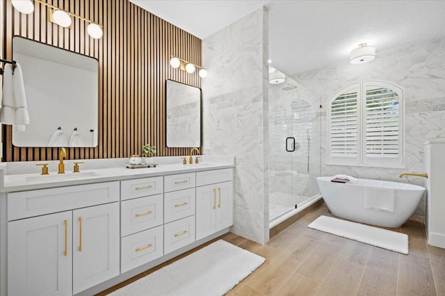 bathroom with hardwood / wood-style floors, vanity, and independent shower and bath